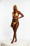 Woman wearing a gold bikini on a white background