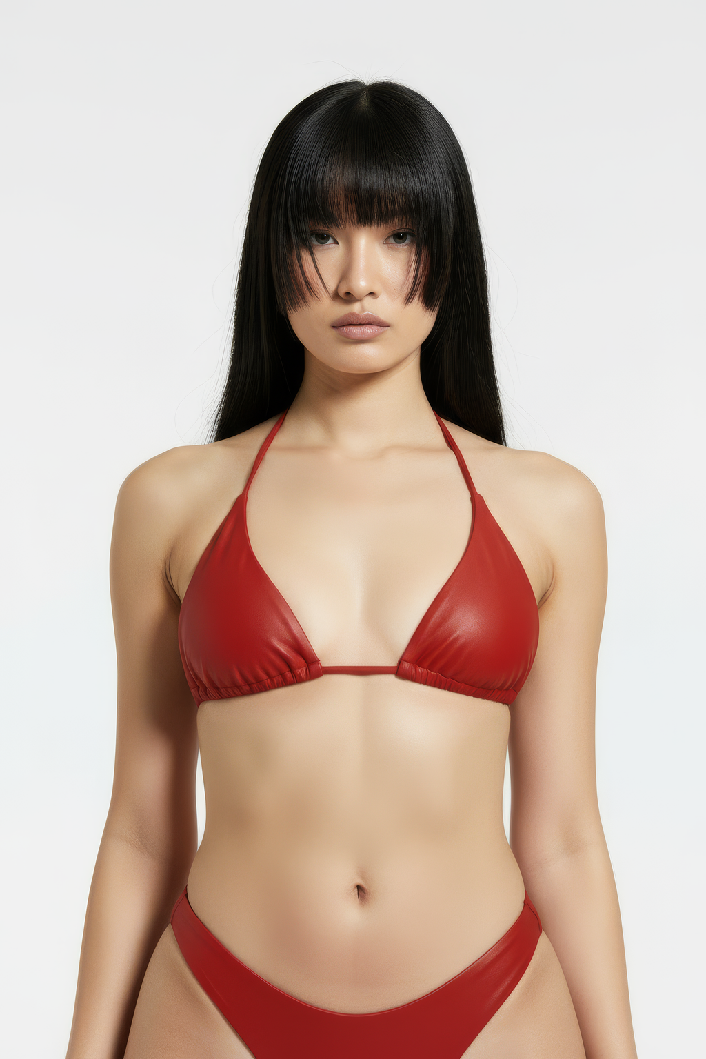 Woman wearing a red bikini  top against a white background